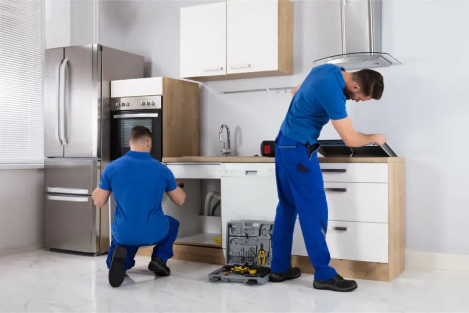 QA Playwright Plumbing technician working under a kitchen sink